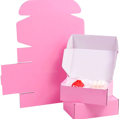 Zawijanie różowego pudełka z tektury falistej do przechowywania przesyłek pocztowych